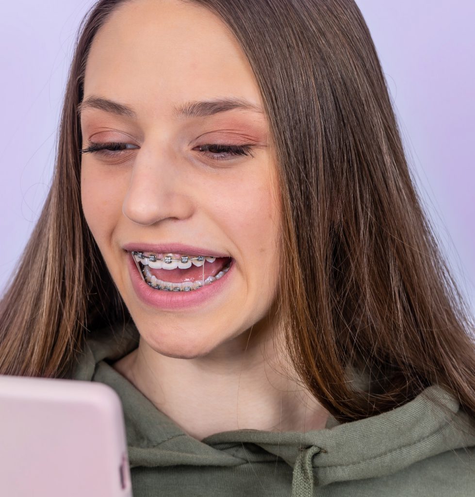 girl with braces and mobile phone